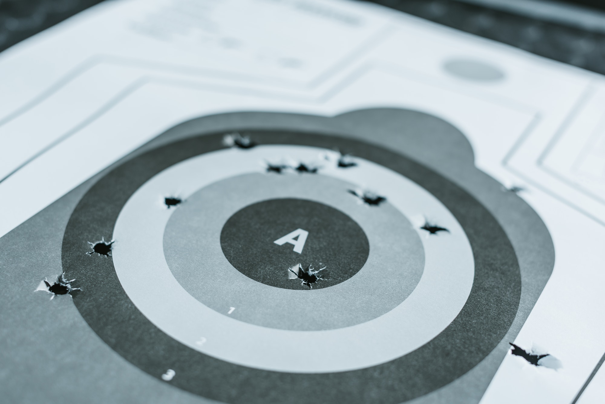 close-up-of-used-gun-target-with-holes-after-bullets.jpg